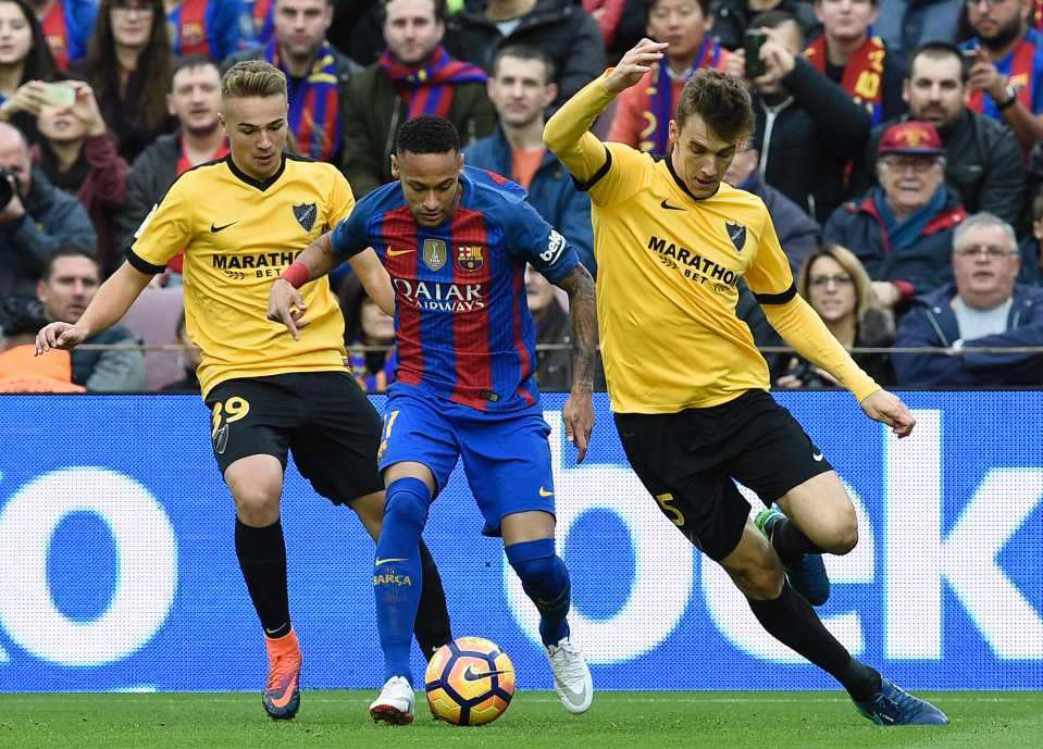  Neymar attempts to run at Malaga's defence but is met by two yellow shirts