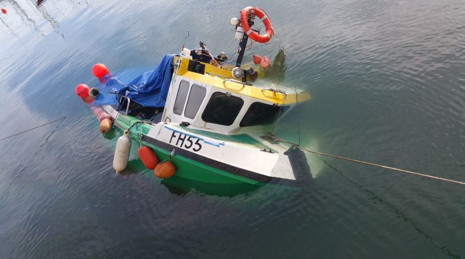  A small boat is towed into shallow water after taking in water in Falmouth