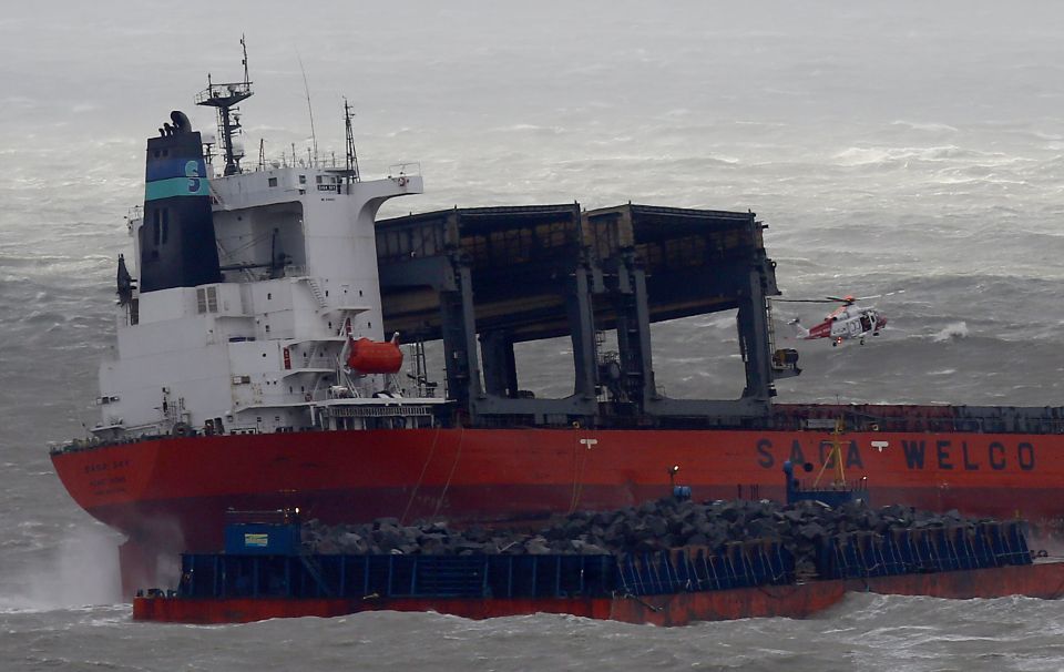  The huge barge filled with rocks is pictured beside the cargo ship