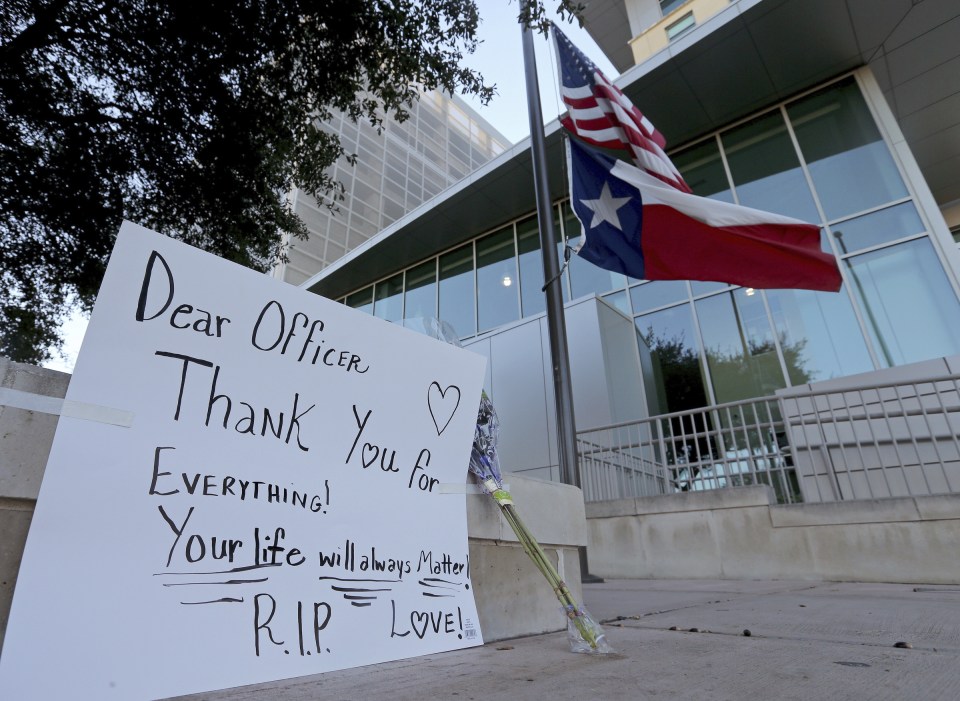  An American flag and a Texas state flag fly at half-mast at San Antonio Police Department headquarters