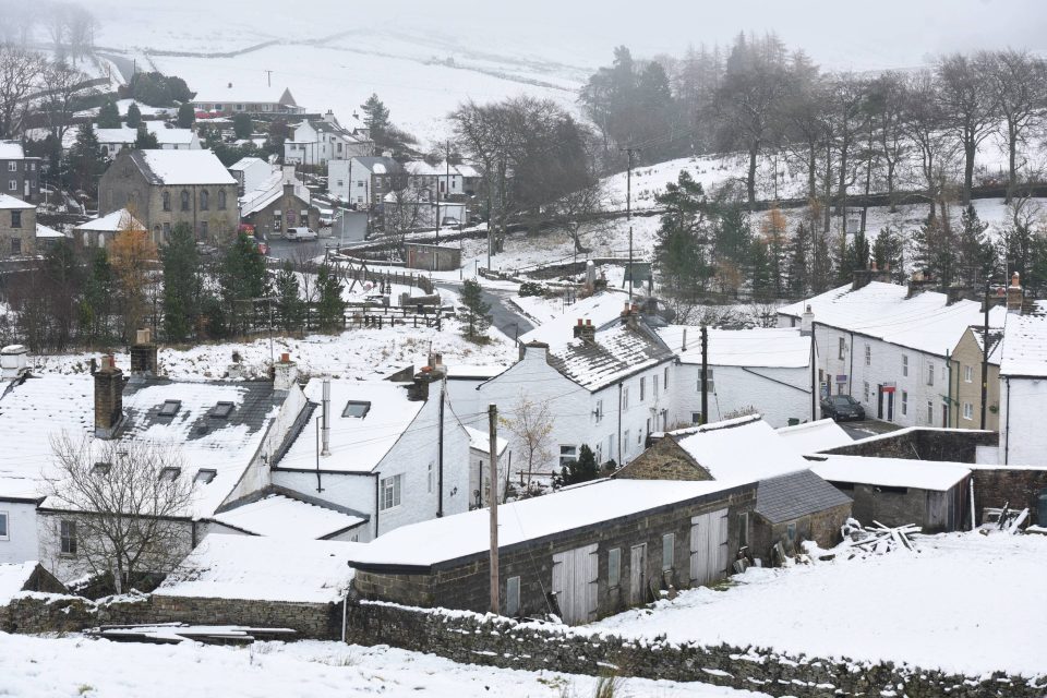  Snow covered the rooftops in the village of Overwater in the North Pennines today while lower climbs experienced severe flooding