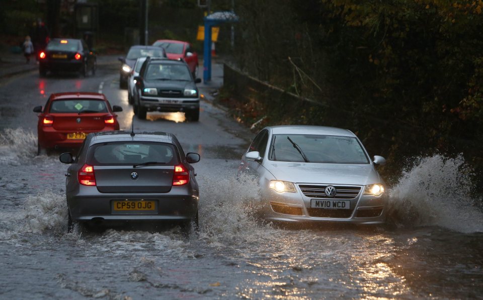  Cars drive on a flooded street outside Port Talbot, south Wales