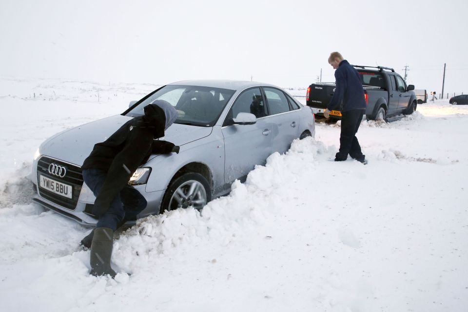  A pickup truck gives another stuck motorist a tow near the Hartside Top cafe on the snowy A686