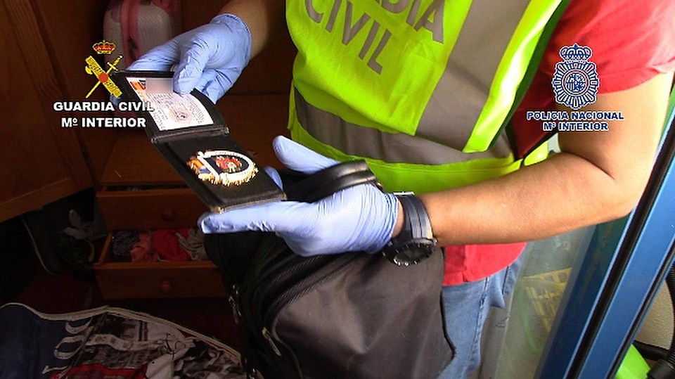  Cops examine evidence at one of the suspected gang member's lair