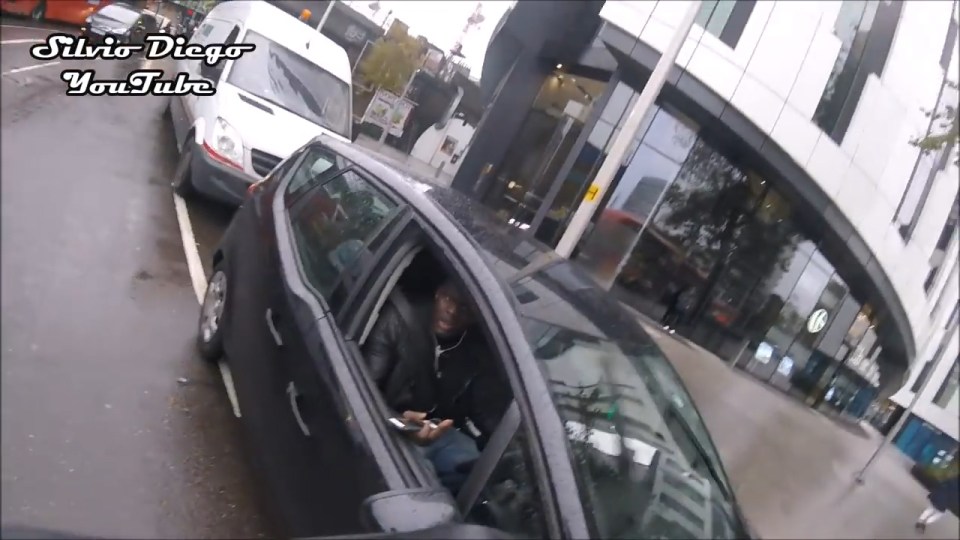 It's then that the cyclist notices the man is using not one, but three devices while in busy traffic