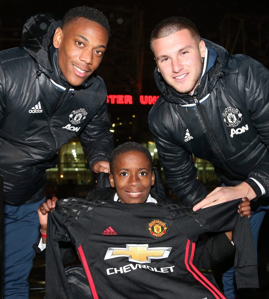 United fan Sam poses with his new shirt alongside Martial and Johnstone