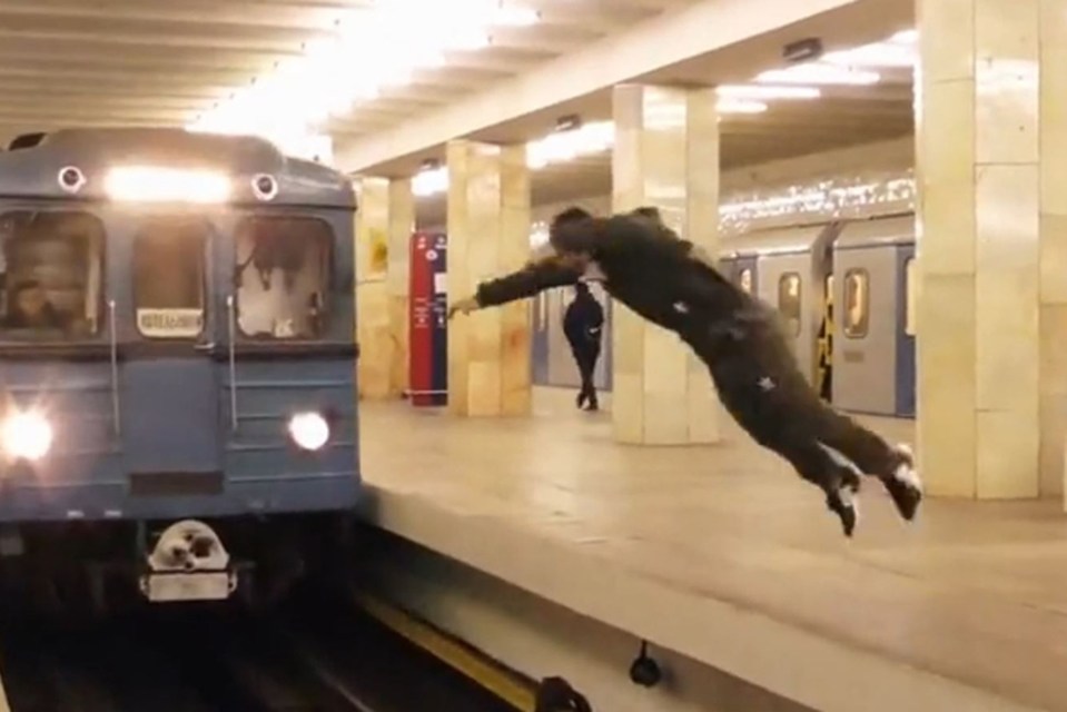  The daredevil hurls himself across the tracks as a train pulls into the station