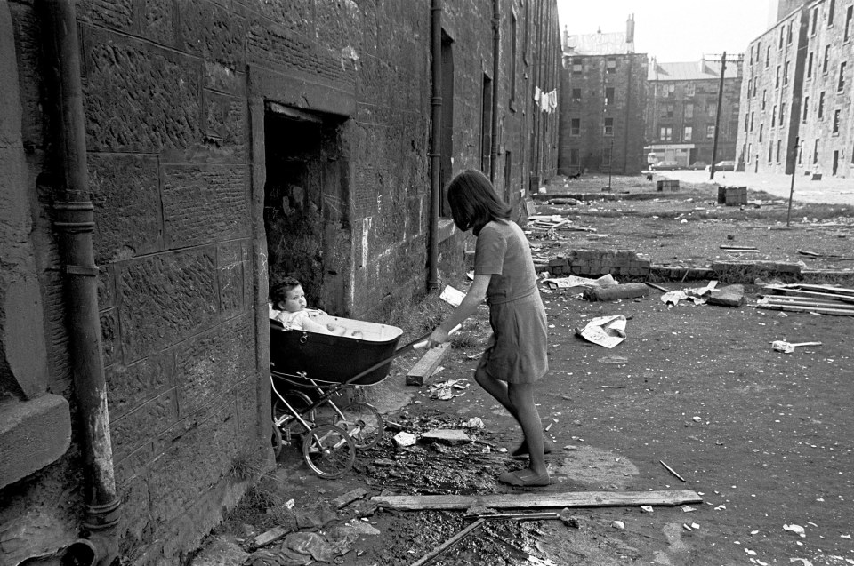  A Mother takes her baby inside her condemned tenement block Gorbals 1970. This image was used in the Regional Scotland Exhibition