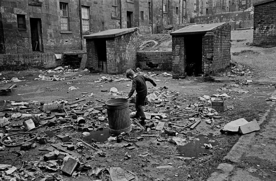  Tenement courtyard Maryhill 1971: A boy playing among rubbish in the courtyard of a tenement building