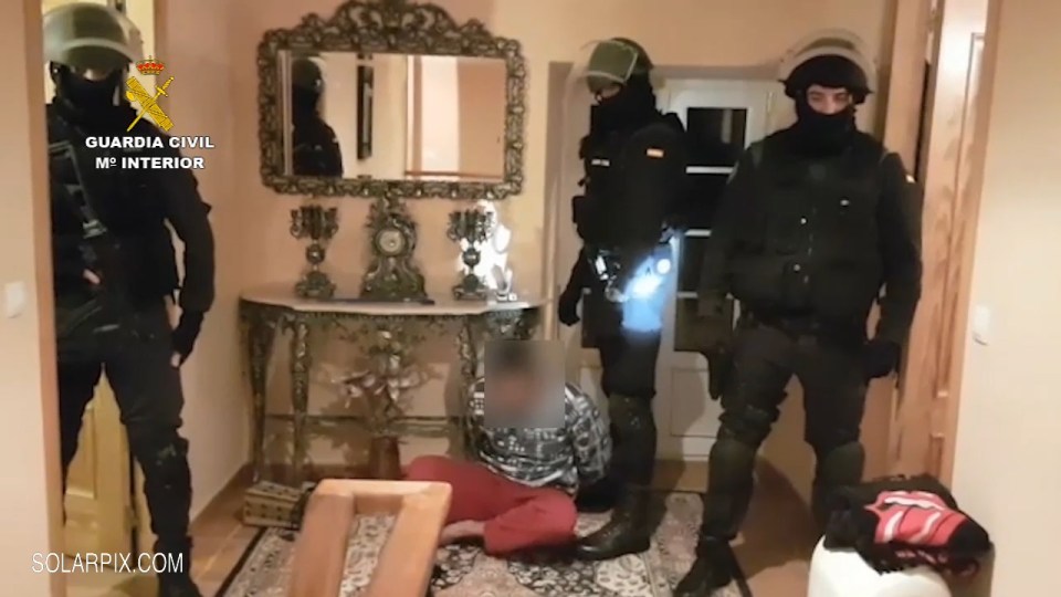  Footage shows some of the officers inside one of the homes, while a handcuffed suspect sits on the floor