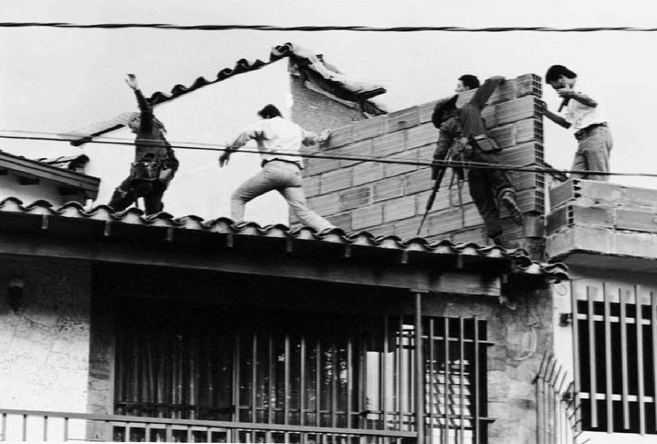  Colombian police and military forces clamber over a rooftop after gunfight with Escobar and his bodyguard