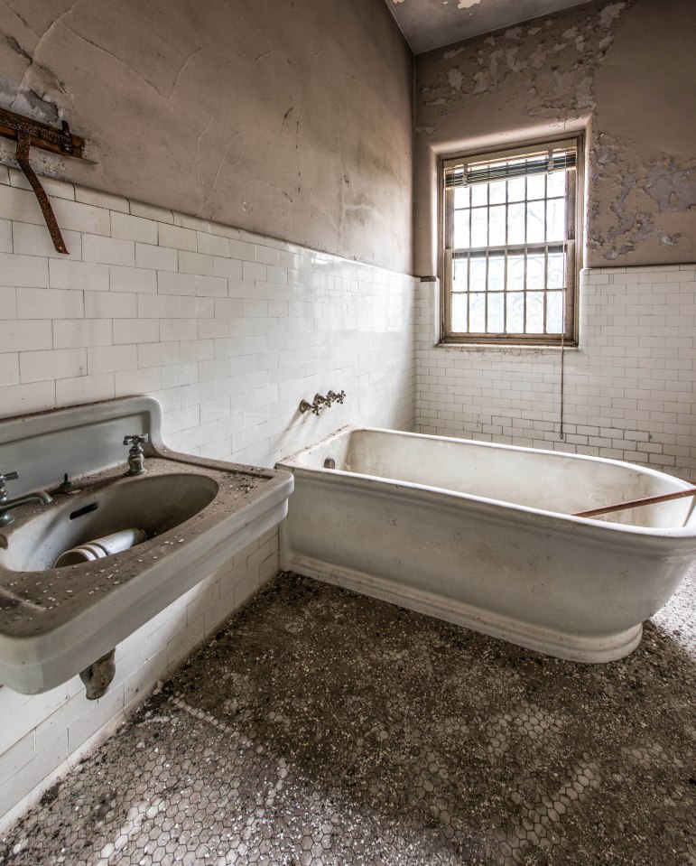  A bathtub is left untouched in one of the bathrooms of the former asylum