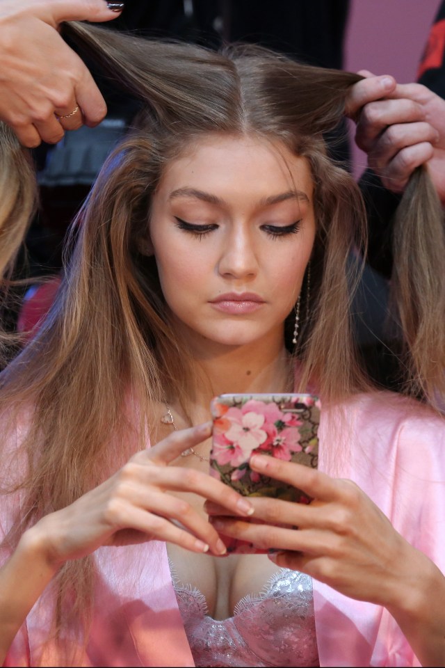  Gigi was pictured tapping away on her phone as she had her hair done