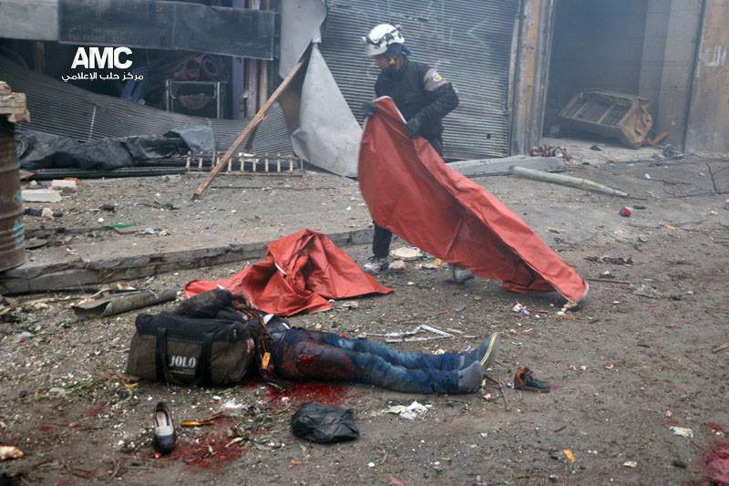  A White Helmet rescue worker covers the body of a man who was killed in a bombing today...his bag is packed