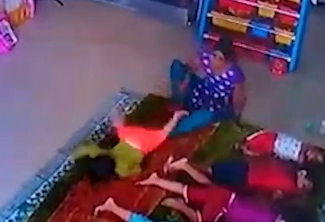  The nursery worker slams the little girl down on the matt, face first