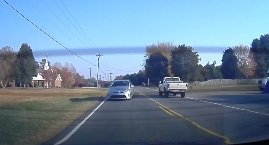 Dozy motorist nearly smashes into a passing car as it swerves to avoid hurtling into the Tesla