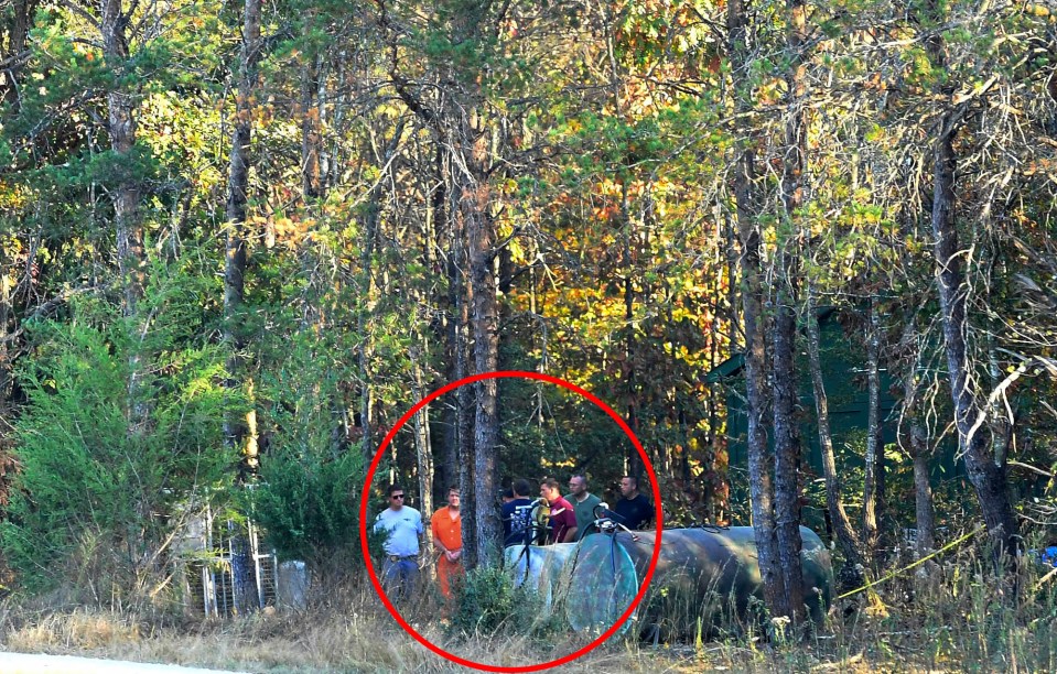  Todd Kohlhepp, in handcuffs and an orange jumpsuit, is escorted by deputies on his property in Woodruff