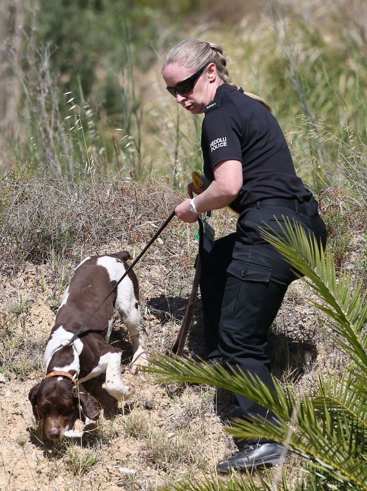  British police with sniffer dogs check an area of scrubland close to where Madeleine McCann went missing in 2007