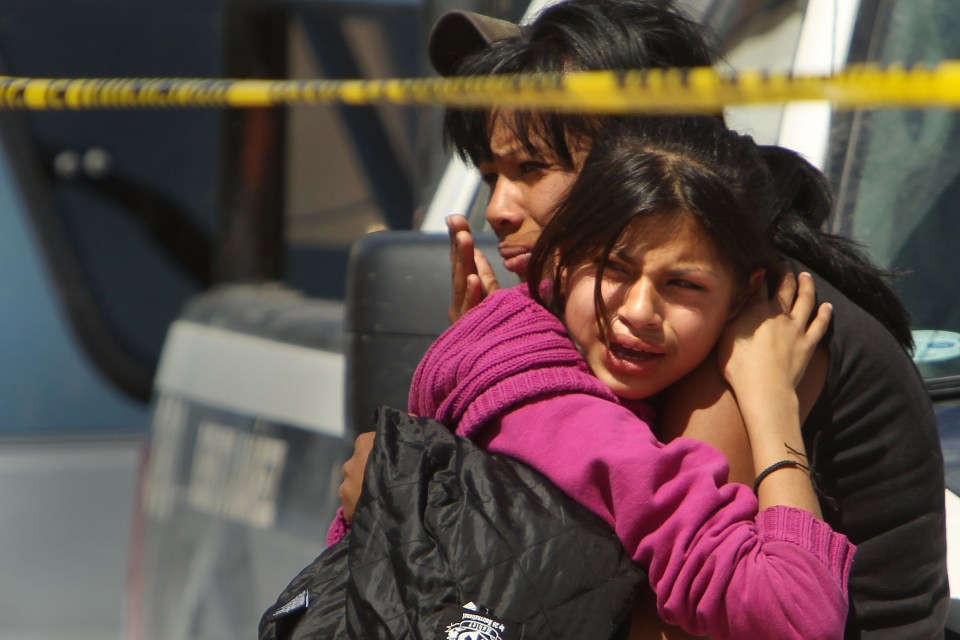  Family members cry in front of a car in which two men were killed in Juarez, Mexico