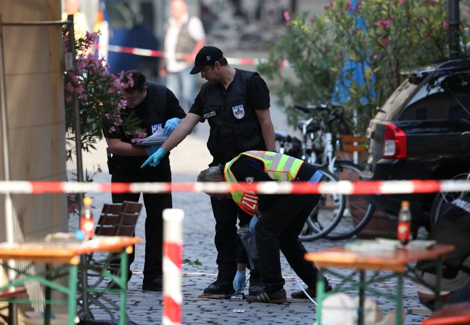  Police officers inspect the scene outside the wine bar where the explosion took place