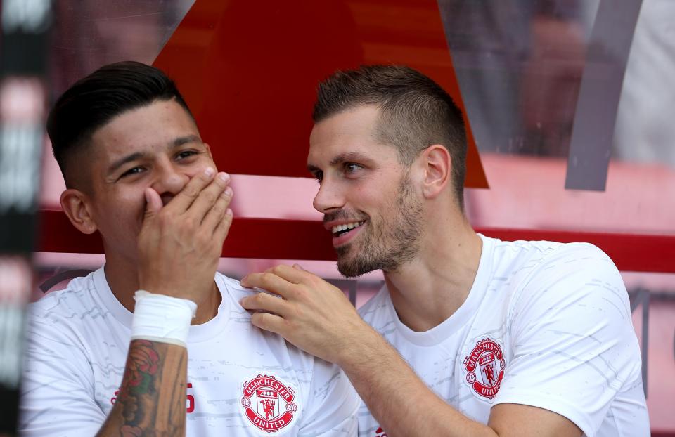  Schneiderlin (right) shares a joke on the subs bench with Marcos Rojo