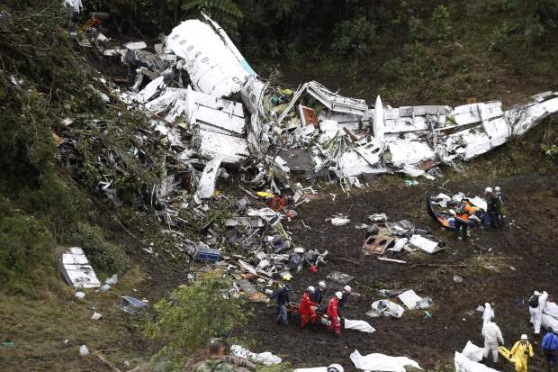 Rescue workers recover a body from the wreckage of the tragic horror crash