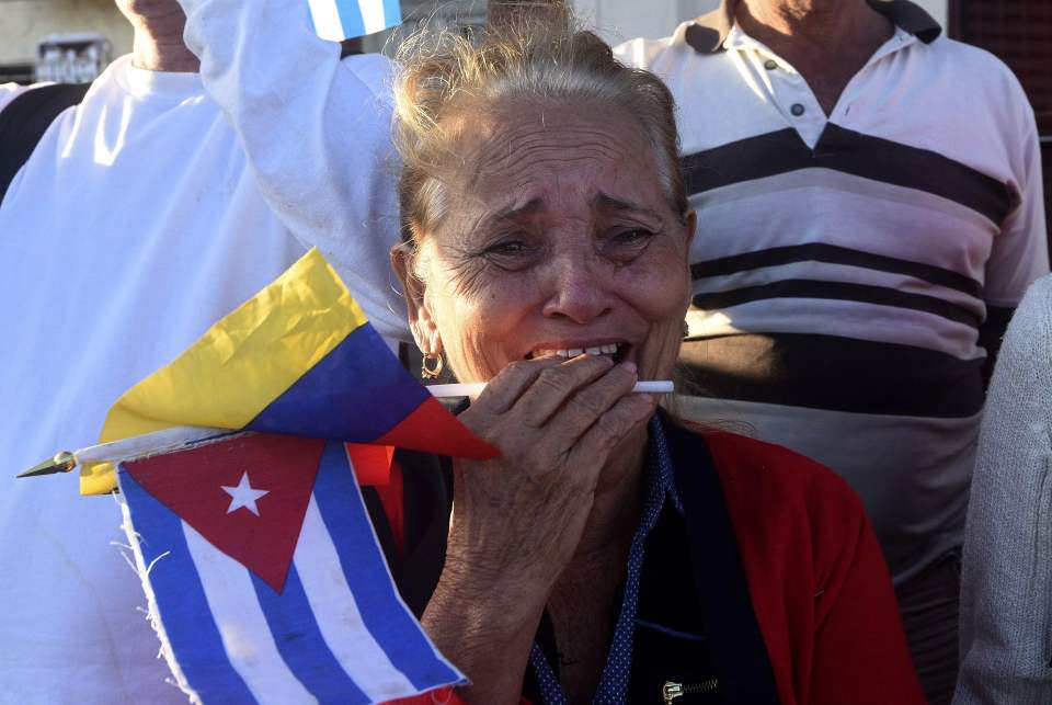  A woman weeps as Fidel's urn is driven through the streets of Havana