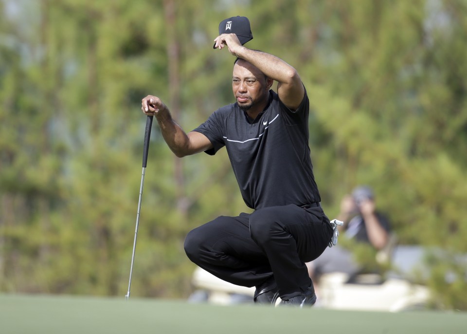 Woods prepares to putt on the 10th