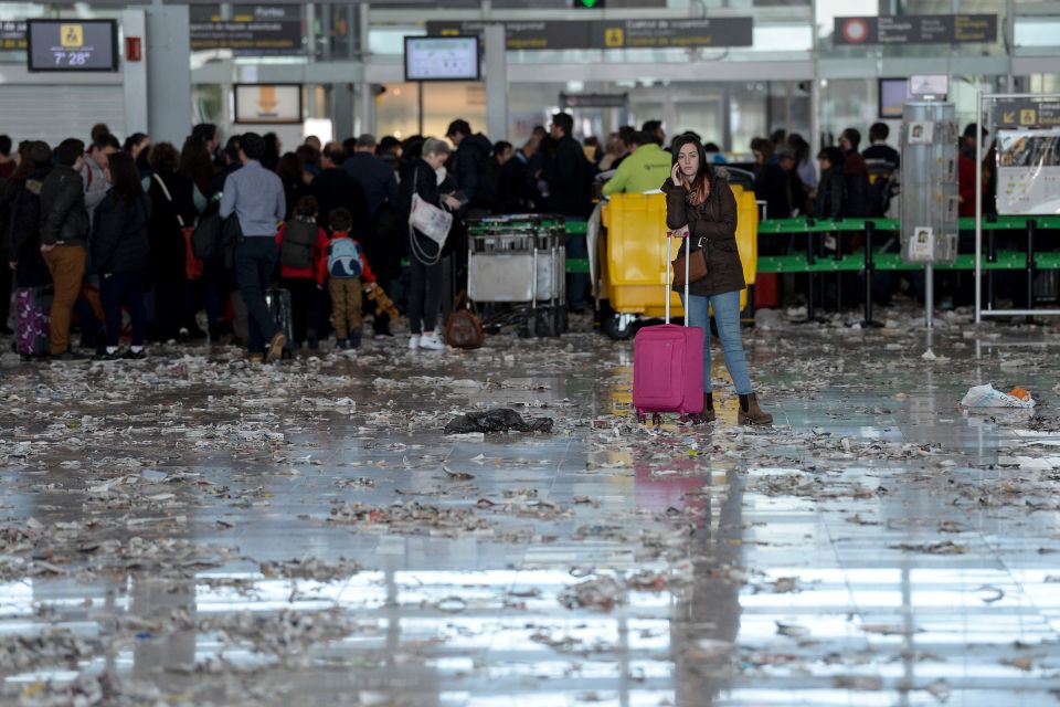  A holidaymaker stands in the middle of a filthy waiting area of Barcelona Airport surrounded by discarded waste