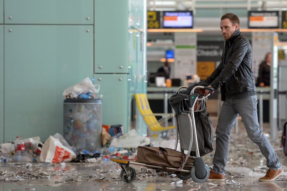  A passenger pushes a trolley through an overflowing bin in the filth strewn airport