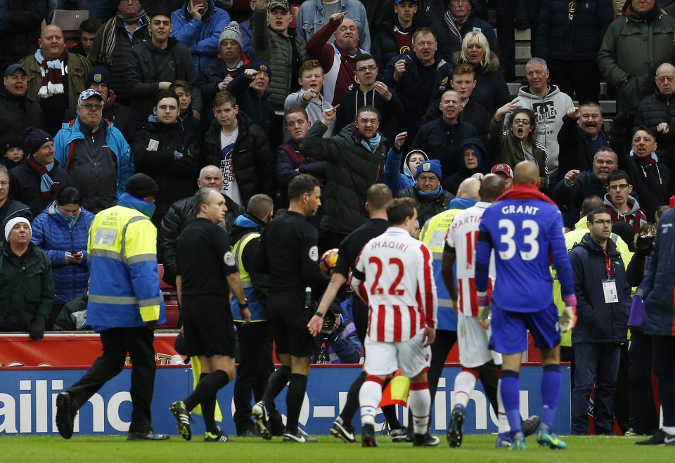  Burnley fans gesture towards referee Mark Clattenburg as he walks off at half time