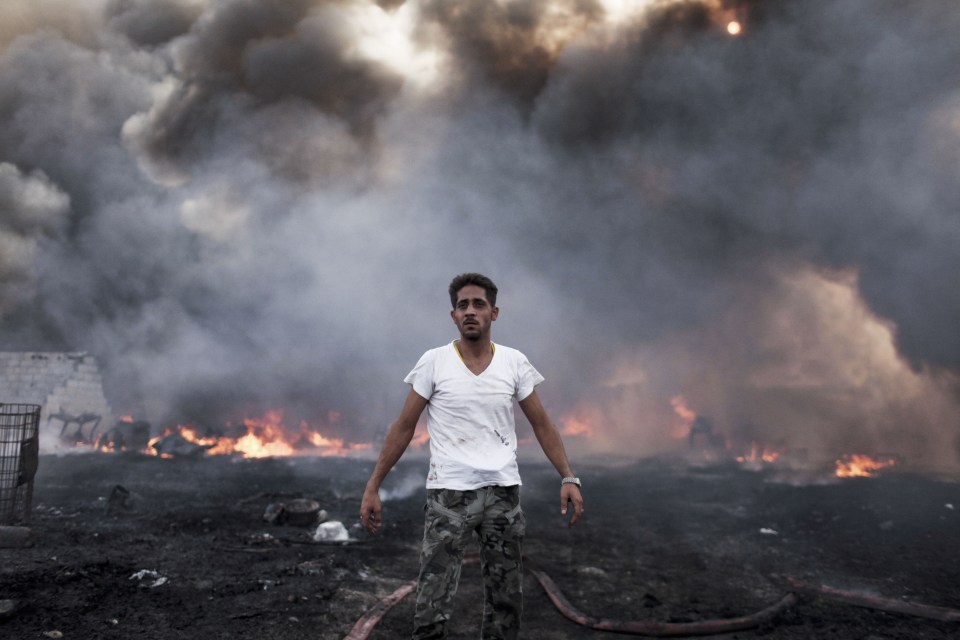  A man stands at the scene of a fire that destroyed a plastic factory in the Khatba district of Tripoli in 2011