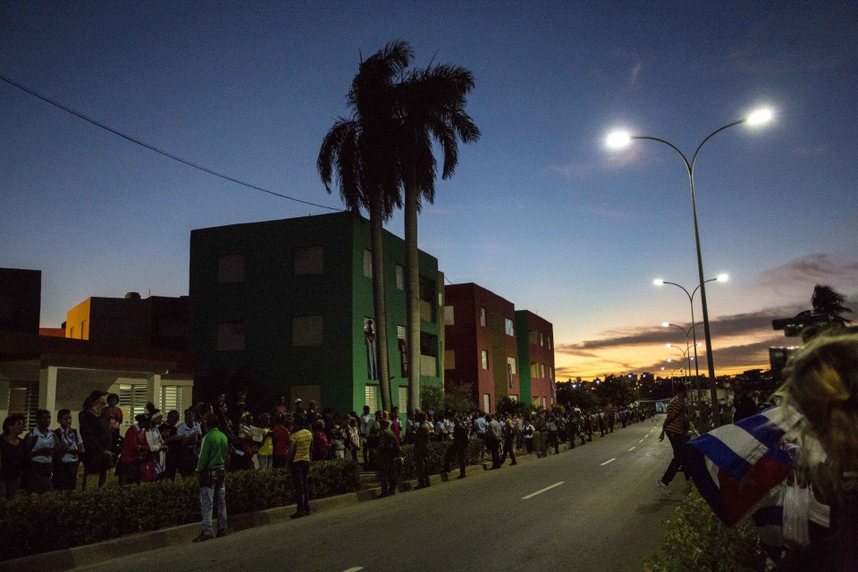  People line the street leading to Santa Ifigenia cemetery as they wait at sunrise for the funeral procession