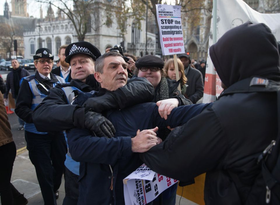  Officers try to break up the fight between protesters