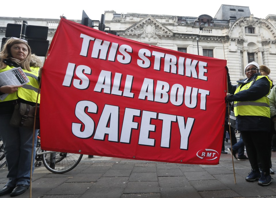  Demonstrators hold a banner outside Victoria station as they start a three-day walkout