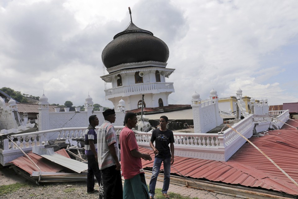  Men inspect a collapsed mosque after an earthquake in Pidie Jaya, Aceh province