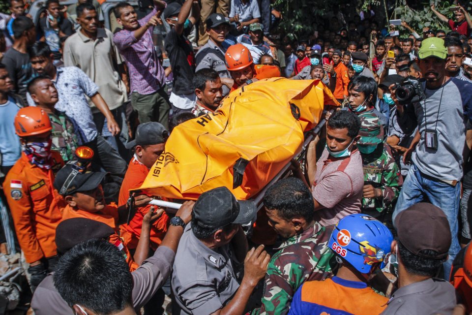  Indonesian rescuers carry the body of a victim