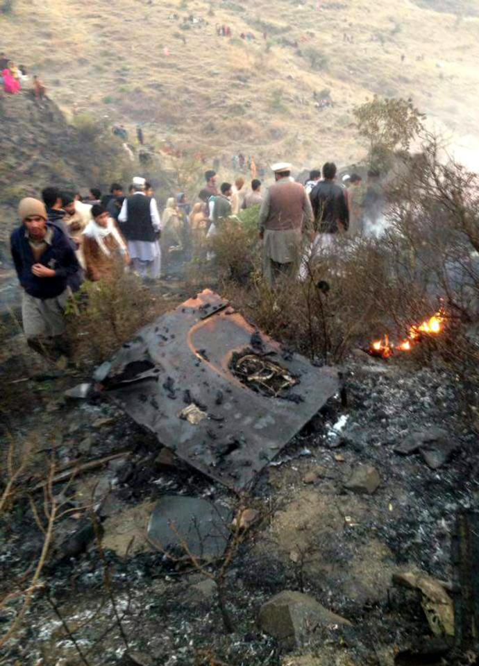  Locals gathering at a plane crash site in Pakistan's Havelian