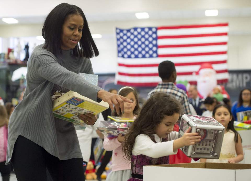 US First Lady Michelle Obama helps to so