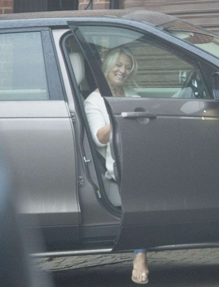  Smile... mystery woman climbs into car at Hoddle's house