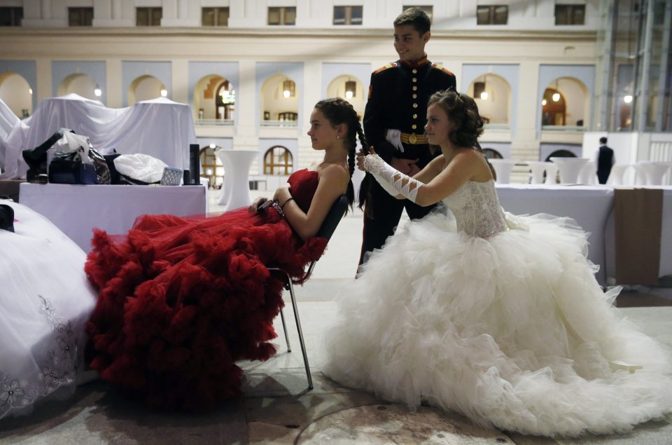  One girl in an elaborate white dress was seen plaiting a friend's hair