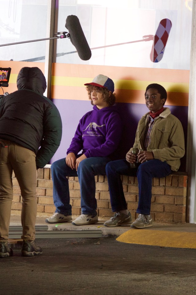  Gaten Matarazzo and Caleb McLaughlin film scenes on a brick well