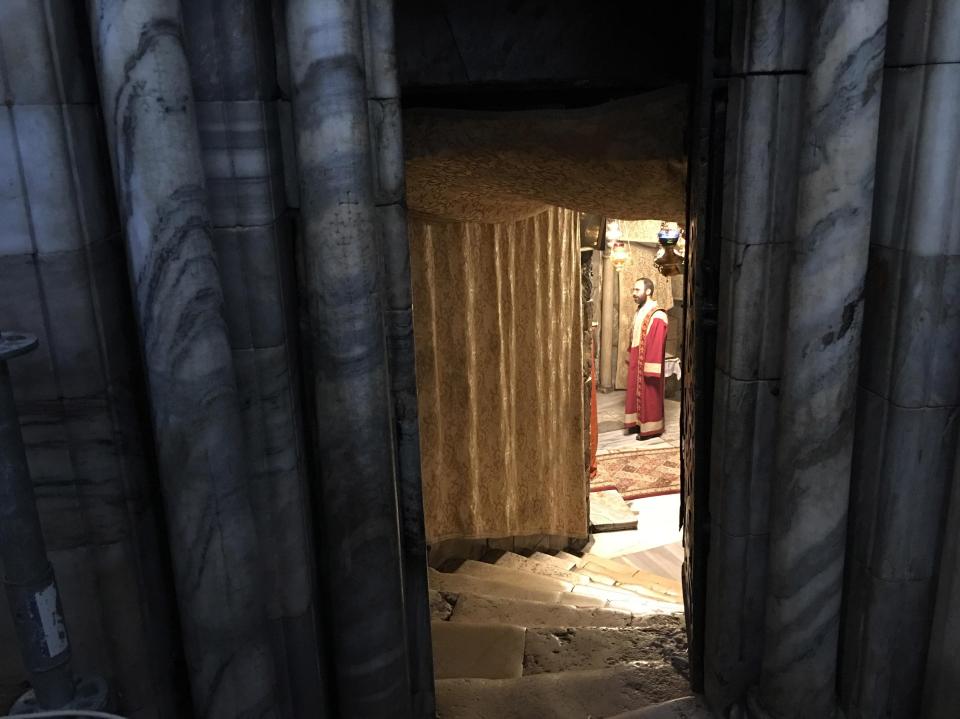  A narrow doorway reveals a clergyman on pilgrimage to one of Christianity's most holy sites