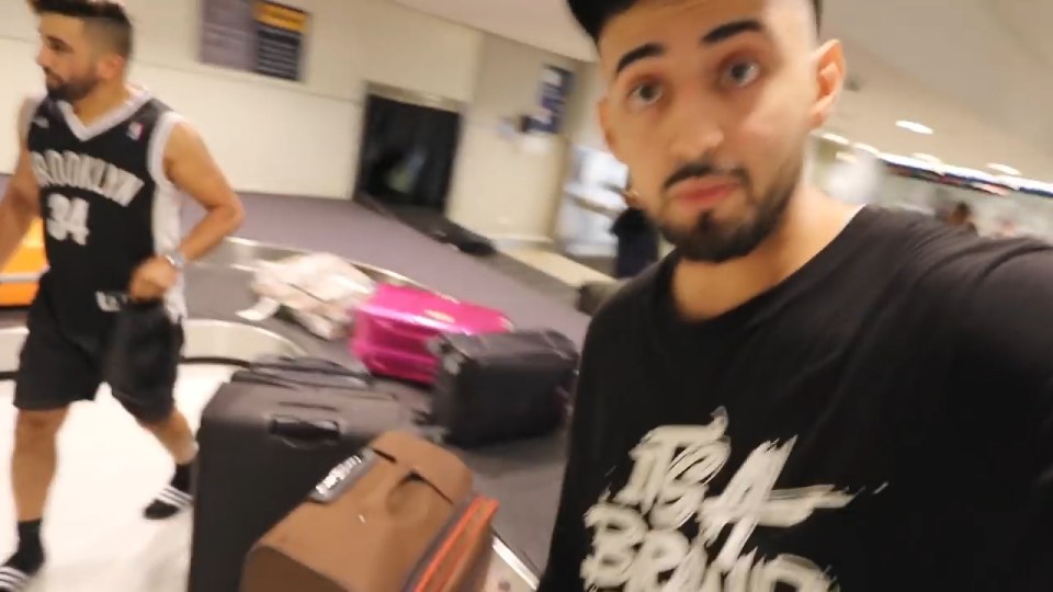 Saleh's friends stand at the luggage carousel in Sydney airport where they claim to be waiting for him to arrive in a suitcase 