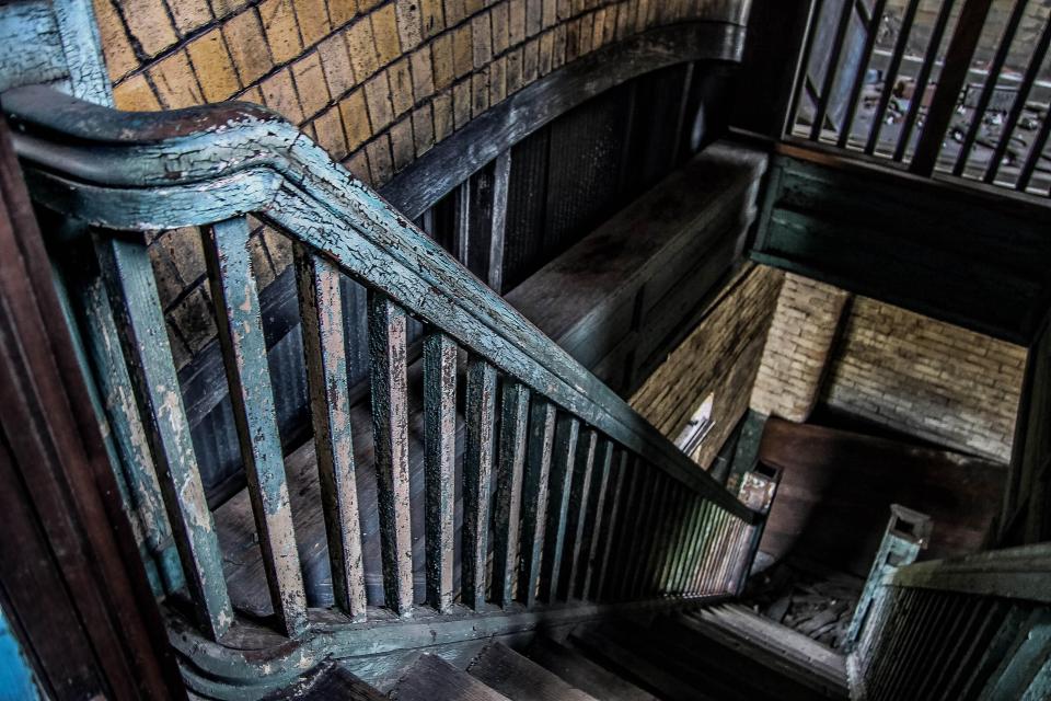  Paint can be seen peeling from the bannisters of an old staircase