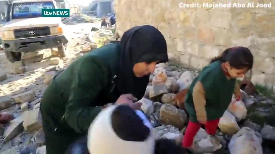 A woman helps herd the terrified children to cover