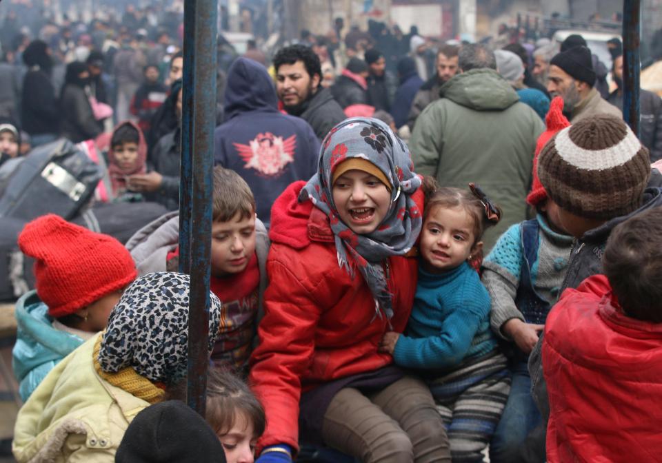  Children play while waiting to be evacuated with others from a rebel-held sector of eastern Aleppo