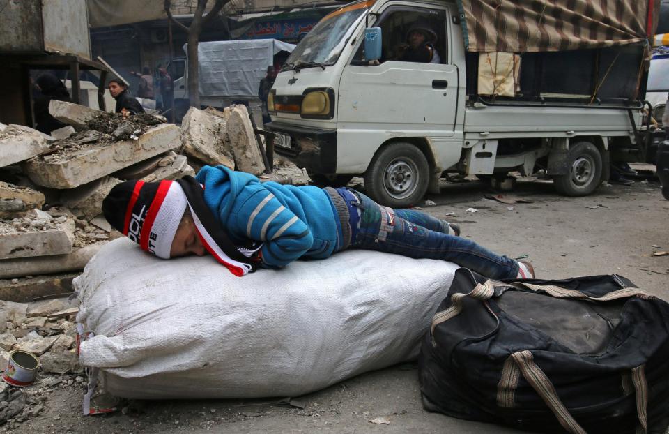  A child sleeps while waiting to be evacuated with others from a rebel-held sector of eastern Aleppo