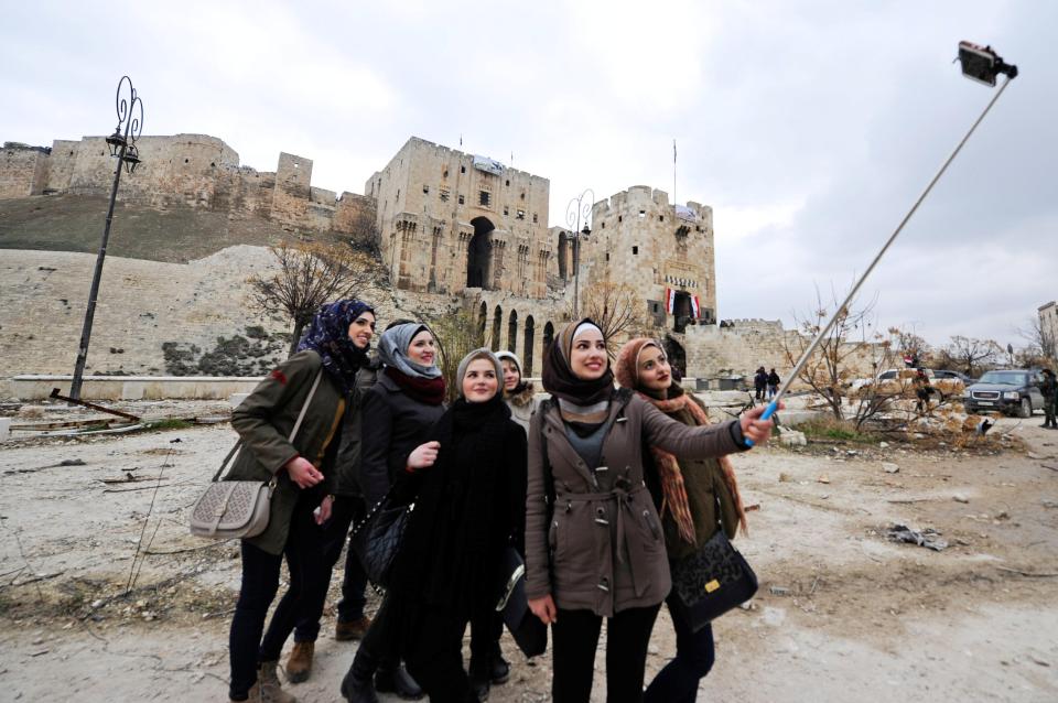  Women take a selfie outside Aleppo's historic citadel, in the government controlled area of the Syrian city