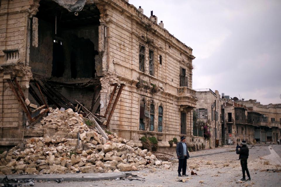  People take pictures in front of the old Customs building in the government controlled Old City of Aleppo